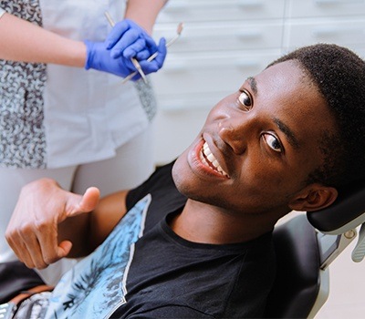 Man giving thumbs up after dental checkup