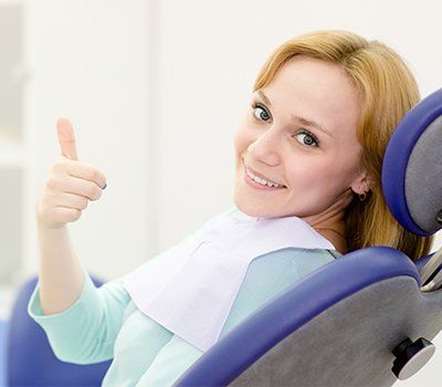 Woman in dental office giving thumbs up