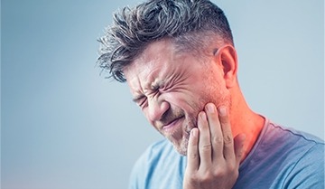 Man with severe jaw pain in need of restorative dentistry