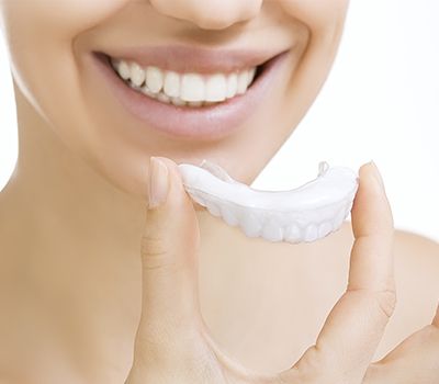 woman holding teeth whitening tray