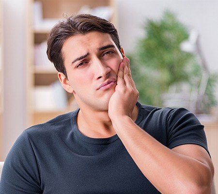 man holding jaw in need of restorative dentistry