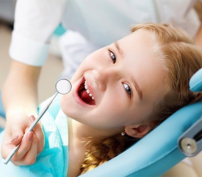 girl looking up at camera during dental checkup