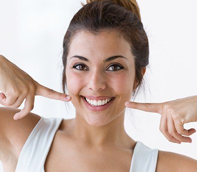 woman pointing to smile after cosmetic dentistry