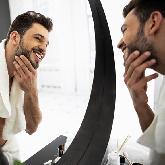 Man looking at his smile in a mirror