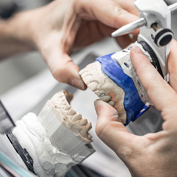 Dental lab worker creating a set of dentures