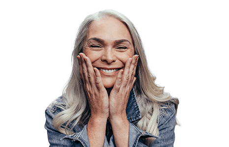 woman holding face smiling after replacing missing teeth