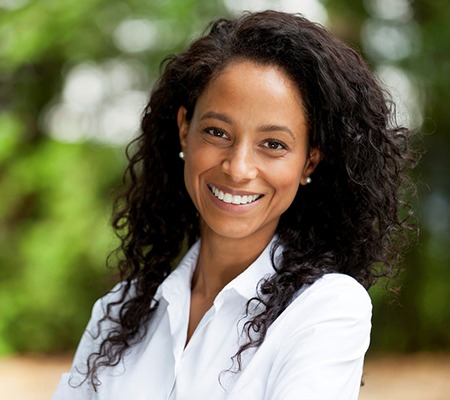 woman in a white button-down shirt smiling with dental implants in Bowie 