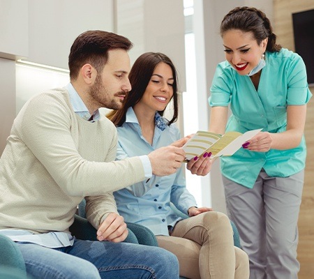 team member showing couple dental insurance paperwork