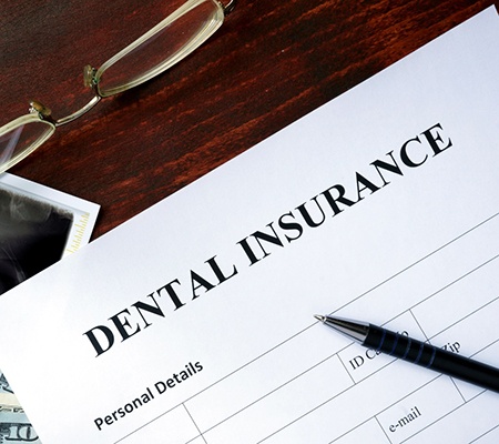 Dental insurance paperwork on wooden desk 
