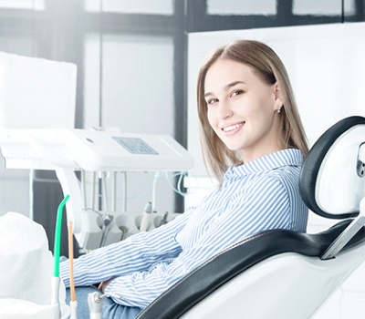 Happy female patient smiling after laser dentistry service