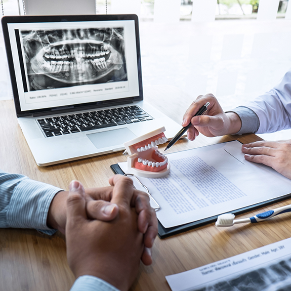 Dentist and a patient sitting at a consultation table