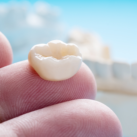 CLose up of a dental crown on a person's finger