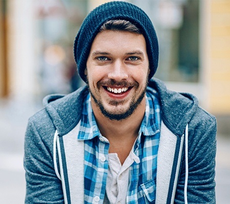 man in beanie with brilliant smile after teeth whitening