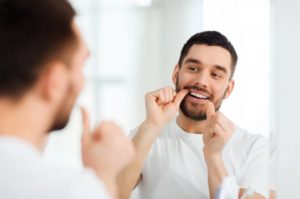 man using dental floss